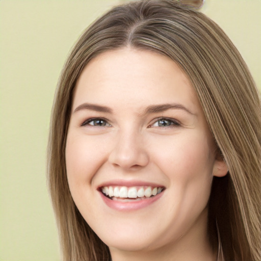 Joyful white young-adult female with long  brown hair and green eyes