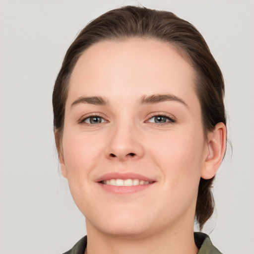 Joyful white young-adult female with medium  brown hair and grey eyes