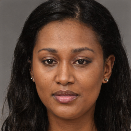 Joyful black adult female with long  brown hair and brown eyes