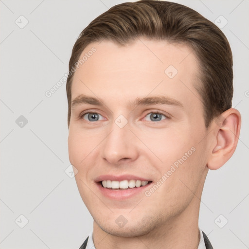 Joyful white young-adult male with short  brown hair and grey eyes