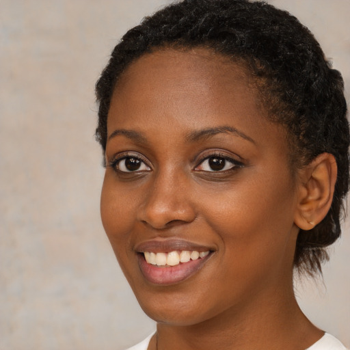 Joyful black young-adult female with medium  brown hair and brown eyes