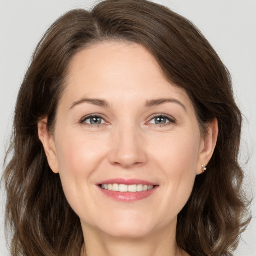 Joyful white adult female with medium  brown hair and brown eyes