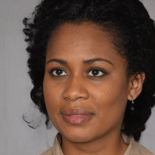 Joyful black young-adult female with medium  brown hair and brown eyes
