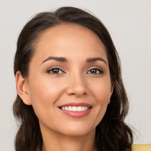 Joyful white young-adult female with long  brown hair and brown eyes