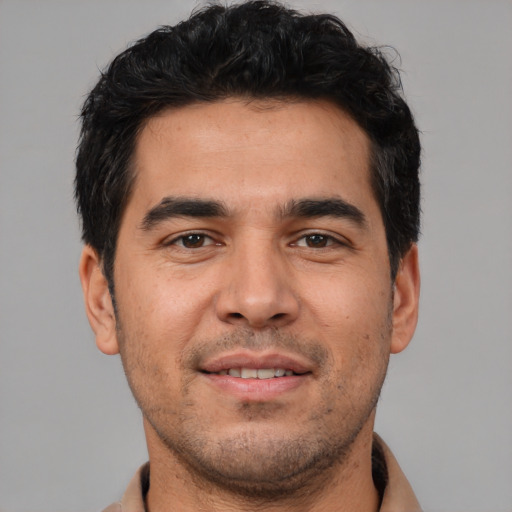 Joyful white young-adult male with short  black hair and brown eyes