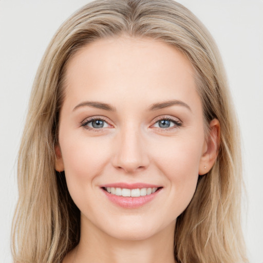 Joyful white young-adult female with long  brown hair and blue eyes