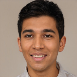 Joyful latino young-adult male with short  black hair and brown eyes