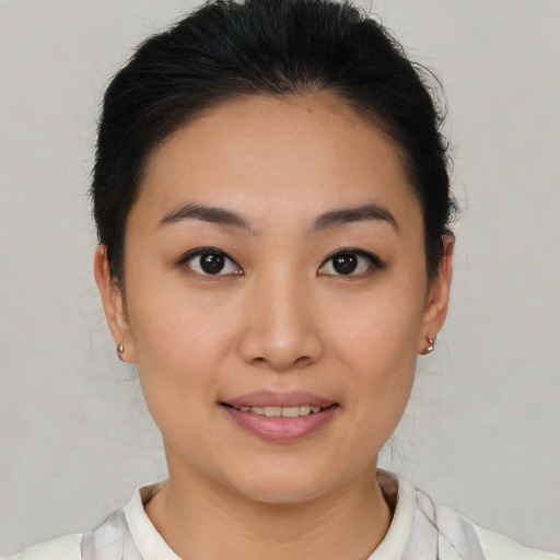 Joyful asian young-adult female with short  brown hair and brown eyes