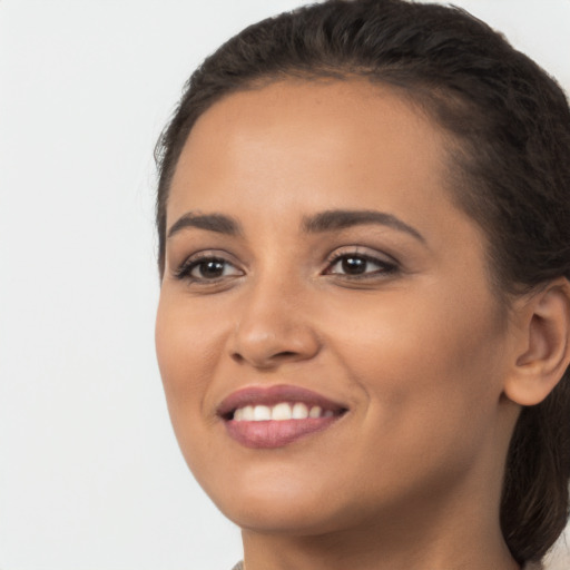 Joyful latino young-adult female with long  brown hair and brown eyes