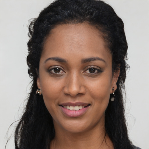 Joyful black young-adult female with long  black hair and brown eyes