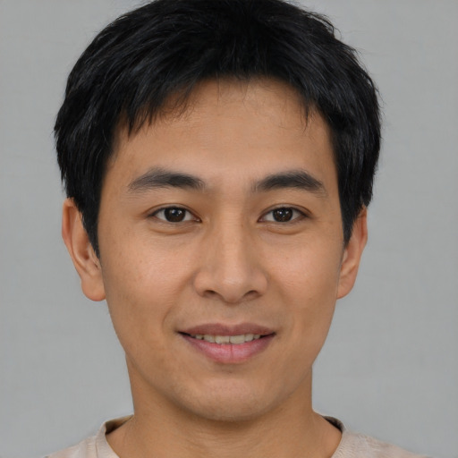 Joyful asian young-adult male with short  black hair and brown eyes