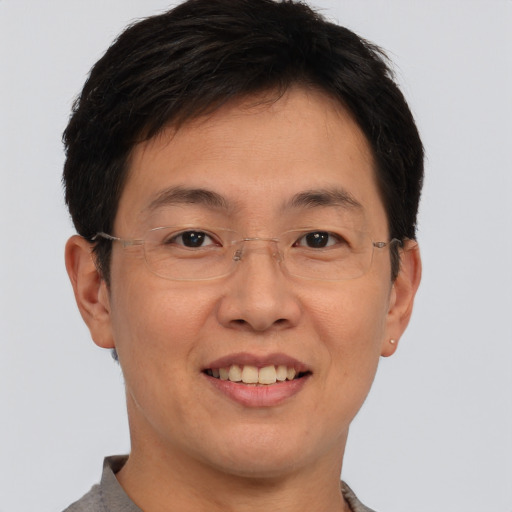 Joyful asian adult male with short  brown hair and brown eyes