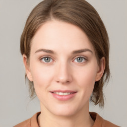 Joyful white young-adult female with medium  brown hair and grey eyes