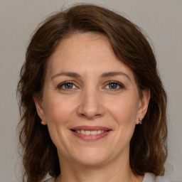 Joyful white adult female with medium  brown hair and grey eyes