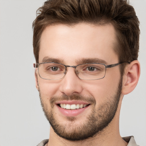 Joyful white young-adult male with short  brown hair and grey eyes