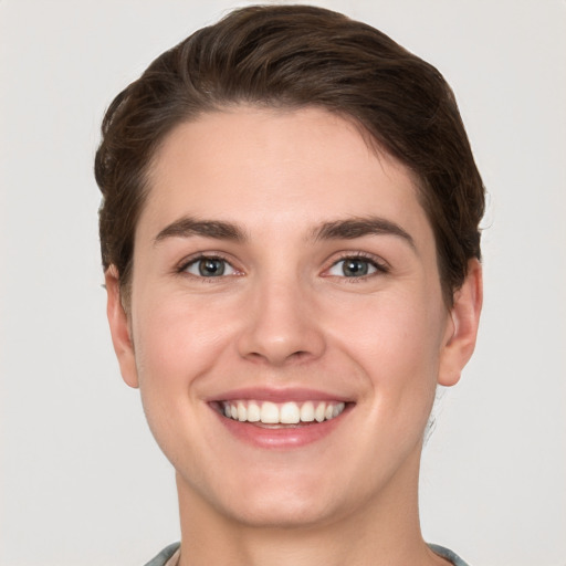 Joyful white young-adult female with short  brown hair and grey eyes