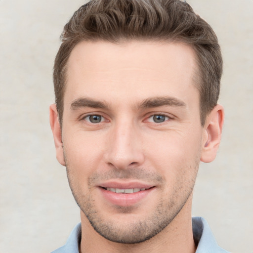 Joyful white young-adult male with short  brown hair and grey eyes