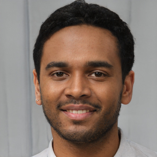 Joyful black young-adult male with short  black hair and brown eyes