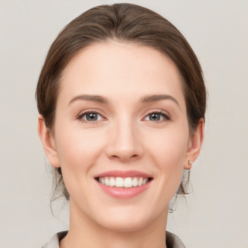 Joyful white young-adult female with medium  brown hair and grey eyes