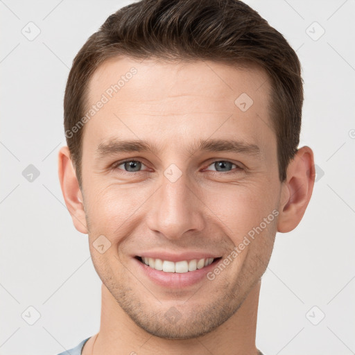 Joyful white young-adult male with short  brown hair and grey eyes