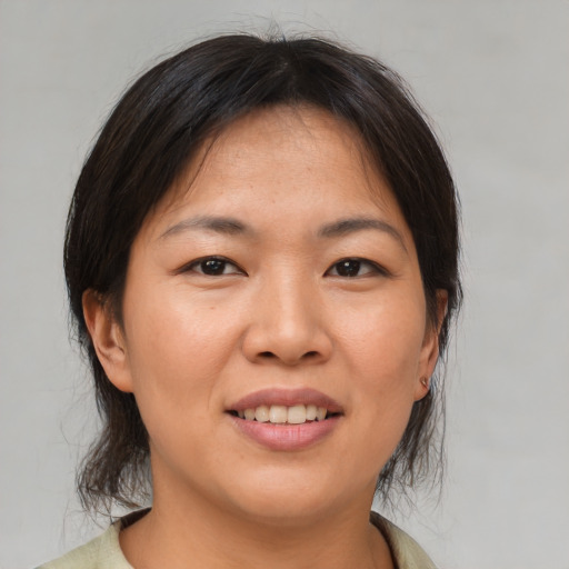 Joyful asian young-adult female with medium  brown hair and brown eyes