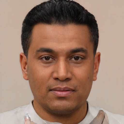 Joyful latino young-adult male with short  black hair and brown eyes