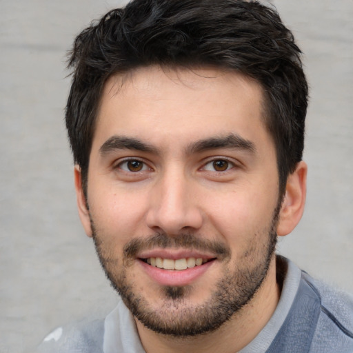 Joyful white young-adult male with short  black hair and brown eyes