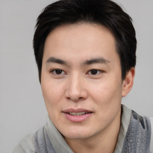 Joyful asian young-adult male with short  black hair and brown eyes