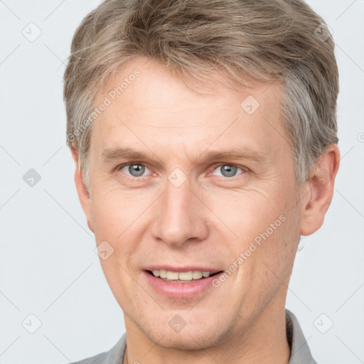 Joyful white adult male with short  brown hair and grey eyes