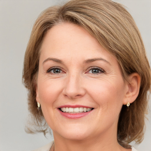 Joyful white adult female with medium  brown hair and grey eyes