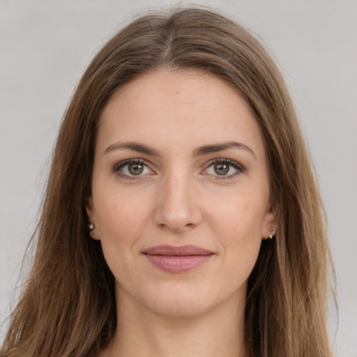 Joyful white young-adult female with long  brown hair and green eyes