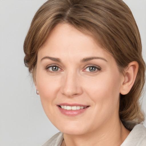 Joyful white adult female with medium  brown hair and grey eyes