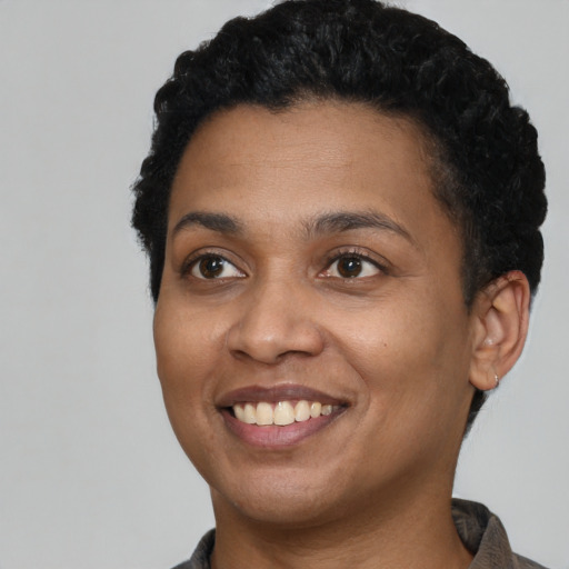 Joyful black young-adult female with short  black hair and brown eyes