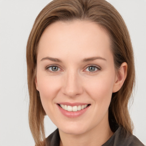 Joyful white young-adult female with long  brown hair and grey eyes