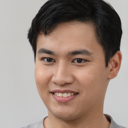 Joyful asian young-adult male with short  brown hair and brown eyes