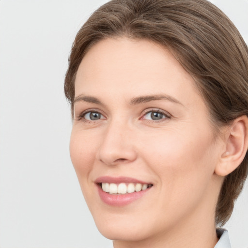 Joyful white young-adult female with long  brown hair and green eyes