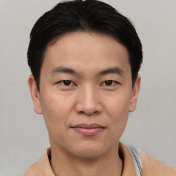 Joyful asian young-adult male with short  brown hair and brown eyes