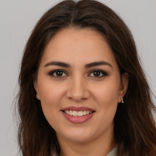 Joyful white young-adult female with long  brown hair and brown eyes