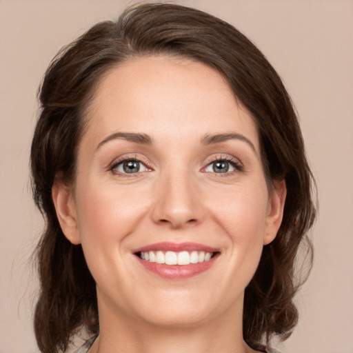 Joyful white young-adult female with medium  brown hair and green eyes