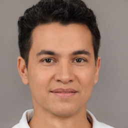 Joyful white young-adult male with short  black hair and brown eyes