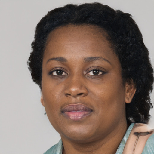 Joyful black adult female with short  black hair and brown eyes