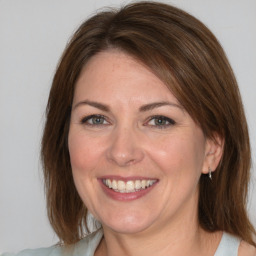 Joyful white adult female with medium  brown hair and brown eyes