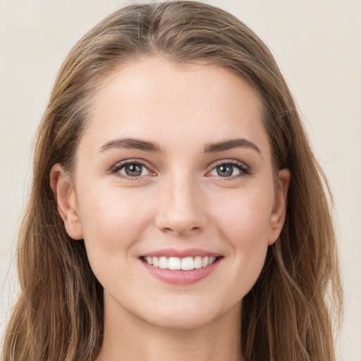 Joyful white young-adult female with long  brown hair and grey eyes