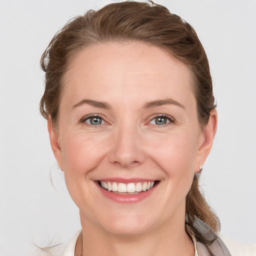 Joyful white adult female with medium  brown hair and grey eyes