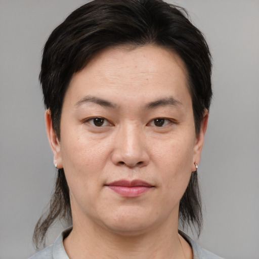 Joyful asian adult female with medium  brown hair and brown eyes