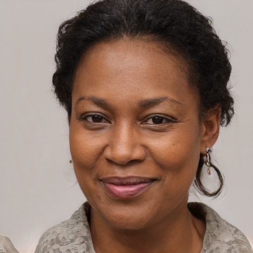 Joyful black adult female with medium  brown hair and brown eyes