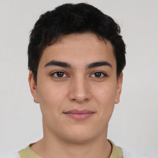 Joyful latino young-adult male with short  black hair and brown eyes