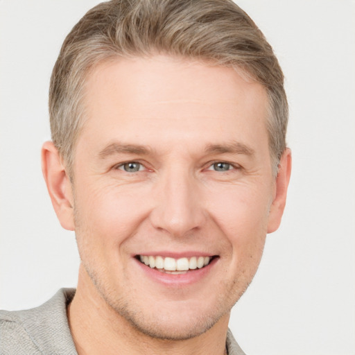 Joyful white adult male with short  brown hair and grey eyes