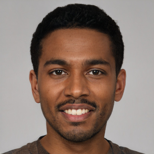 Joyful black young-adult male with short  black hair and brown eyes