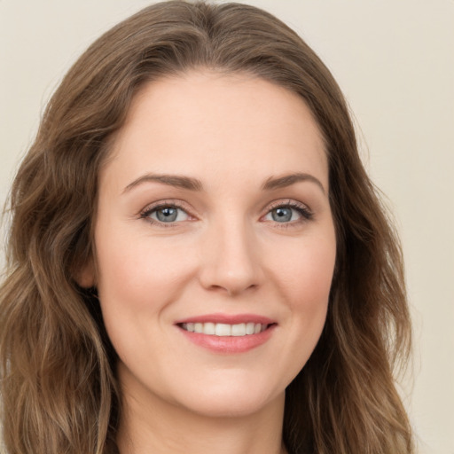 Joyful white young-adult female with long  brown hair and green eyes